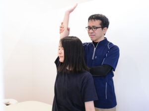 座位で肩の施術を受ける女性