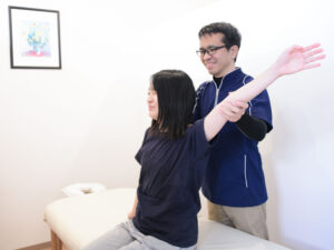 座位で整体を受ける女性