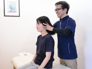 巻き肩の整体を受ける女性